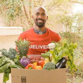 Man Carrying a Box Full of Vegetables